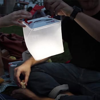 A-solar-lantern-lighting-up-at-night-while-held-by-hands